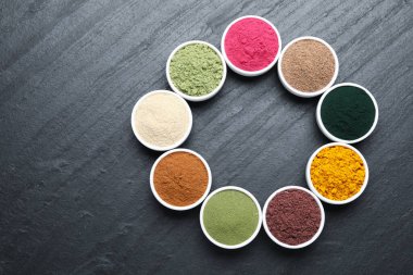 Siyah masanın üzerinde farklı süper yiyecek tozları var. Metin için boşluk