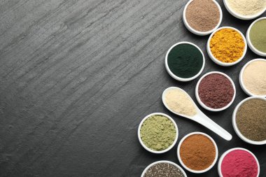 Siyah masanın üzerinde farklı süper yiyecek tozları var. Metin için boşluk