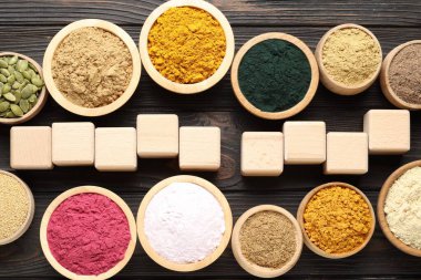 Farklı süper gıda ürünleri ve tahta masanın üzerinde boş küpler.