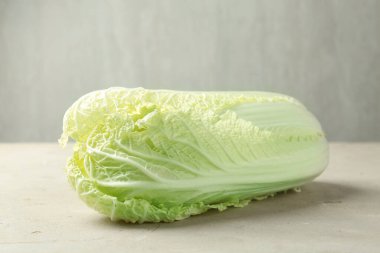 Açık gri masada taze Çin lahanası, yakın plan.