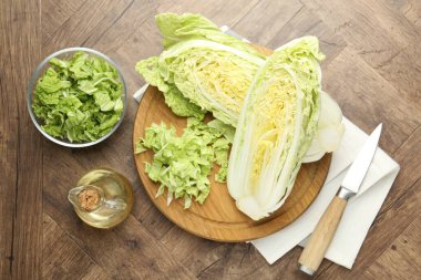 Taze kesilmiş Çin lahanası, yağ ve bıçak ahşap masada, düz yatıyordu.