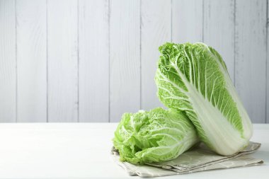 Beyaz ahşap masada taze Çin lahanaları, metin için yer.