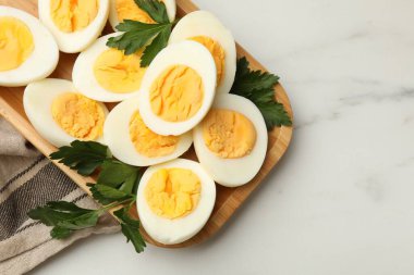 Beyaz mermer masada haşlanmış yumurta ve maydanoz, üst manzara. Metin için boşluk