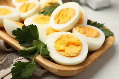 Beyaz masada haşlanmış yumurta ve maydanoz, yakın plan.