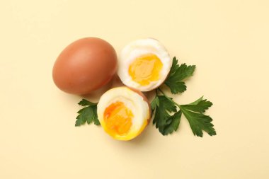 Bej arka planda kaynamış yumurta ve maydanoz.