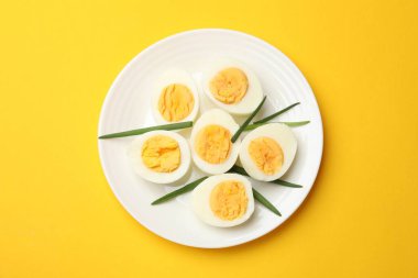Sarı arka planda haşlanmış yumurta ve yeşil soğan.