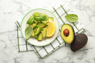 Lezzetli yeşil avokadolar, fesleğen ve limon beyaz mermer masa, düz yatıyordu.