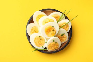 Sarı arka planda yeşil soğanlı haşlanmış yumurtalar.