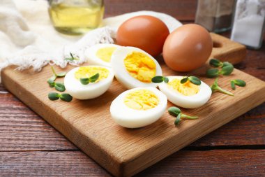 Tahta masanın üzerinde mikro yeşillikli haşlanmış yumurtalar, yakın plan.