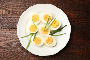 Haşlanmış yumurta ve ahşap masada yeşil soğan.