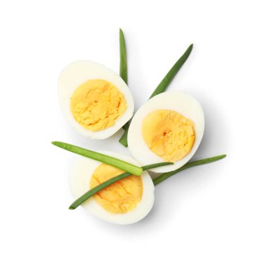 Haşlanmış yumurtaların yarısı ve yeşil soğanlar beyaza izole edilmiş.