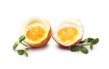 Beyaz zemin üzerinde mikro yeşillikler olan yumuşak haşlanmış yumurtalar.