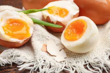 Ahşap masada yeşil soğanlı kaynamış yumurta, yakın plan.