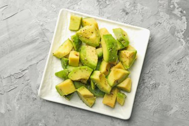 Gri desenli masa üzerinde soslu leziz avokadolar.