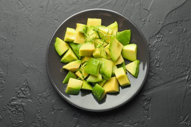 Siyah masa üzerinde lezzetli avokado ve kekik, üst görünüm