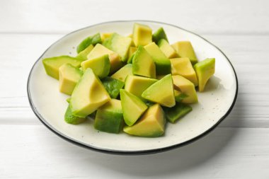 Beyaz ahşap masada lezzetli avokadolar, yakın plan.