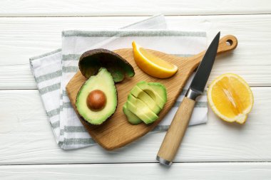 Lezzetli avokadolar, limon ve bıçak beyaz ahşap masa, düz uzanma
