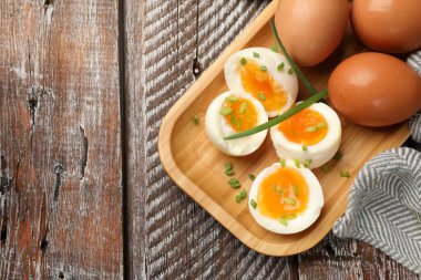 Ahşap masada yeşil soğanlı kaynamış yumurta, üst manzara. Metin için boşluk