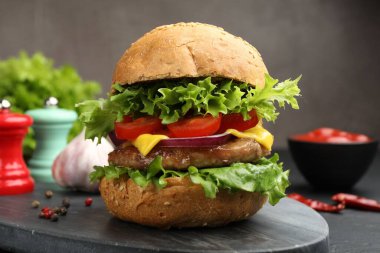 Köfteli lezzetli hamburger, siyah masada servis ediliyor, yakın plan.