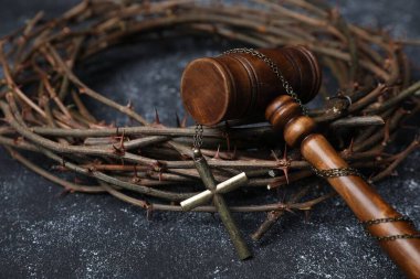 Dikenli taç ve hakimin tokmağı. Arka planda haç var. Yakın plan.