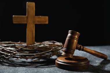 Dikenli taç, yargıç tokmağı ve ahşap haç, koyu dokulu arka plan, yakın plan.