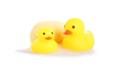 Şirin plastik ördekler ve süngerli süngerler beyaz üzerine izole edilmiş.