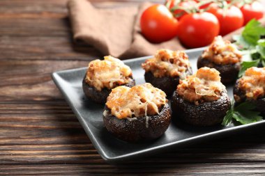 Maydanozlu mantarlar ve ahşap masada domatesler, yakın plan.