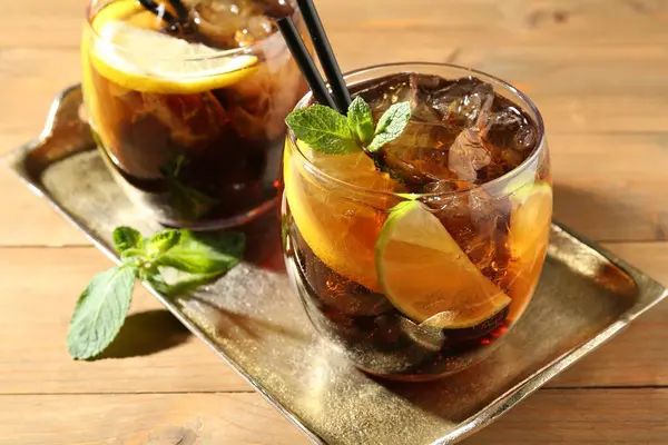 Küba libre kokteylini ahşap masada nane şekeri ile tazeliyorum.