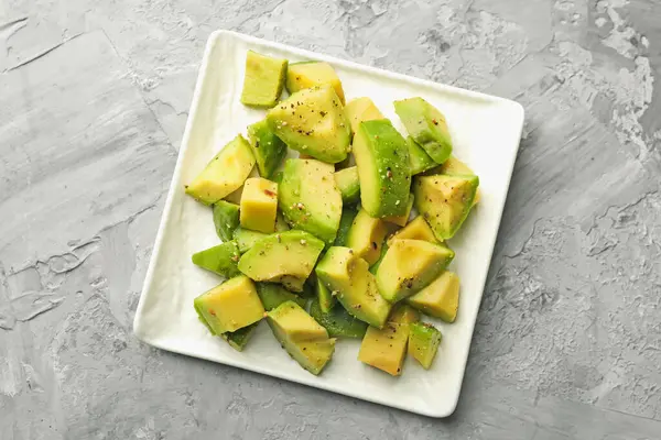 Gri desenli masa üzerinde soslu leziz avokadolar.