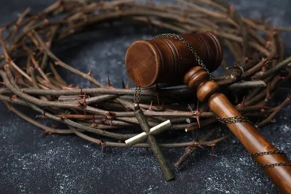 Dikenli taç ve hakimin tokmağı. Arka planda haç var. Yakın plan.
