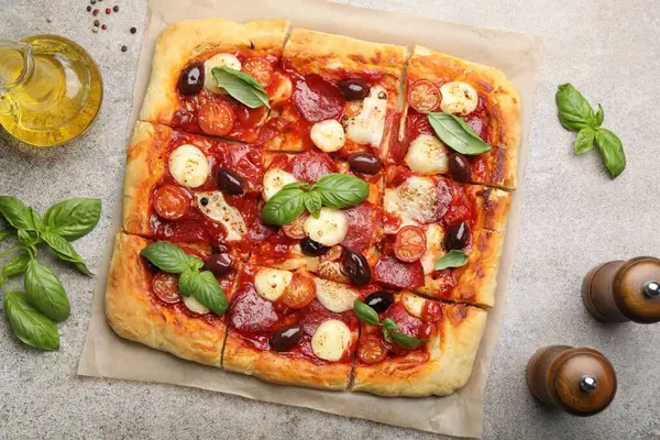 Gri arka planda ev yapımı lezzetli pizza ve baharatlar.