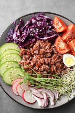 Gri masada kahverengi pirinçli lezzetli bir salata.