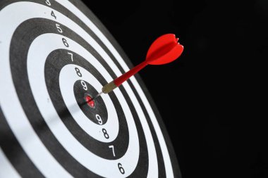 Hedef alınıyor. Siyah arkaplanda ok olan dart tahtası, yakın plan