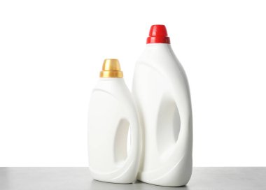 Beyaz arkaplana karşı gri masada yumuşatıcı şişeler