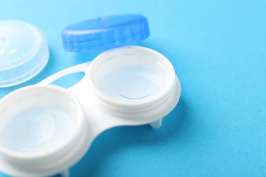 Açık mavi arka planda kontak lensler, yakın plan. Metin için boşluk