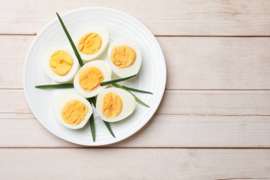 Haşlanmış yumurta ve ahşap masada yeşil soğan, üst manzara. Metin için boşluk