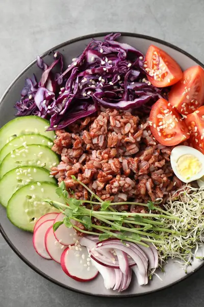 Gri masada kahverengi pirinçli lezzetli bir salata.