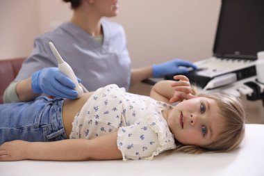 Sonograf, klinikte küçük bir kızın karın ultrasonu muayenesi yapıyor.