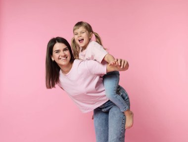 Mutlu anne ve tatlı kızı pembe arka planda