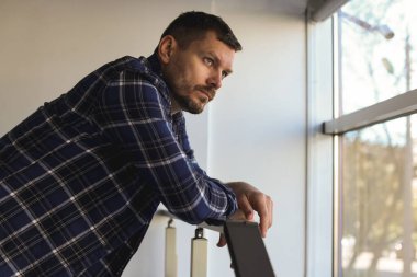 Binanın penceresinin yanında depresif bir adam var. Zihinsel sağlık sorunu