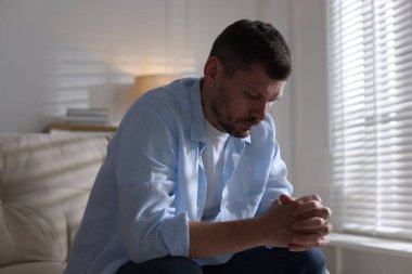 Evdeki kanepede depresif bir adam. Zihinsel sağlık sorunu