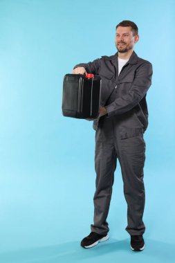 Açık mavi arkaplanda plastik kutu tutan adam, metin için boşluk