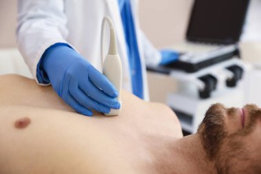 Sonograf, klinikte adamın kalbinin ultrason muayenesi yapıyor.