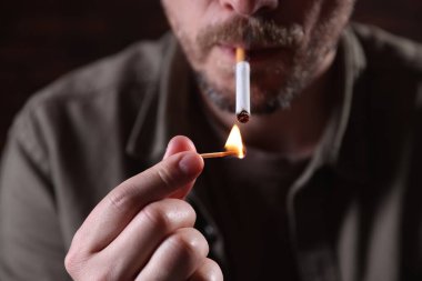 Arka planda kibrit yakan adam, yakın plan.
