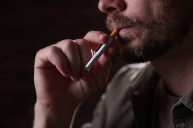 Arka planda sigara içen adam, yakın plan.