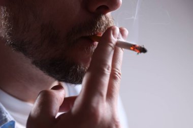 Arka planda sigara içen adam, yakın plan.