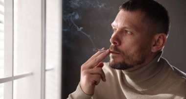 Pencerenin yanında sigara içen adam, mesaj için yer var.