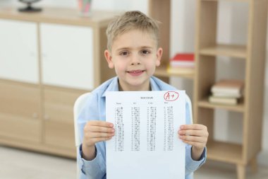 Okul derecesi. A harfiyle cevap kağıdını tutan mutlu çocuk ve kapalı alanda sembol.