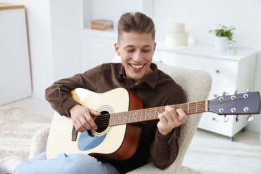 İçerideki koltukta gitar çalan mutlu adam.
