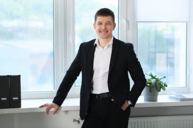 Pencerenin yanındaki yakışıklı adamın portresi.